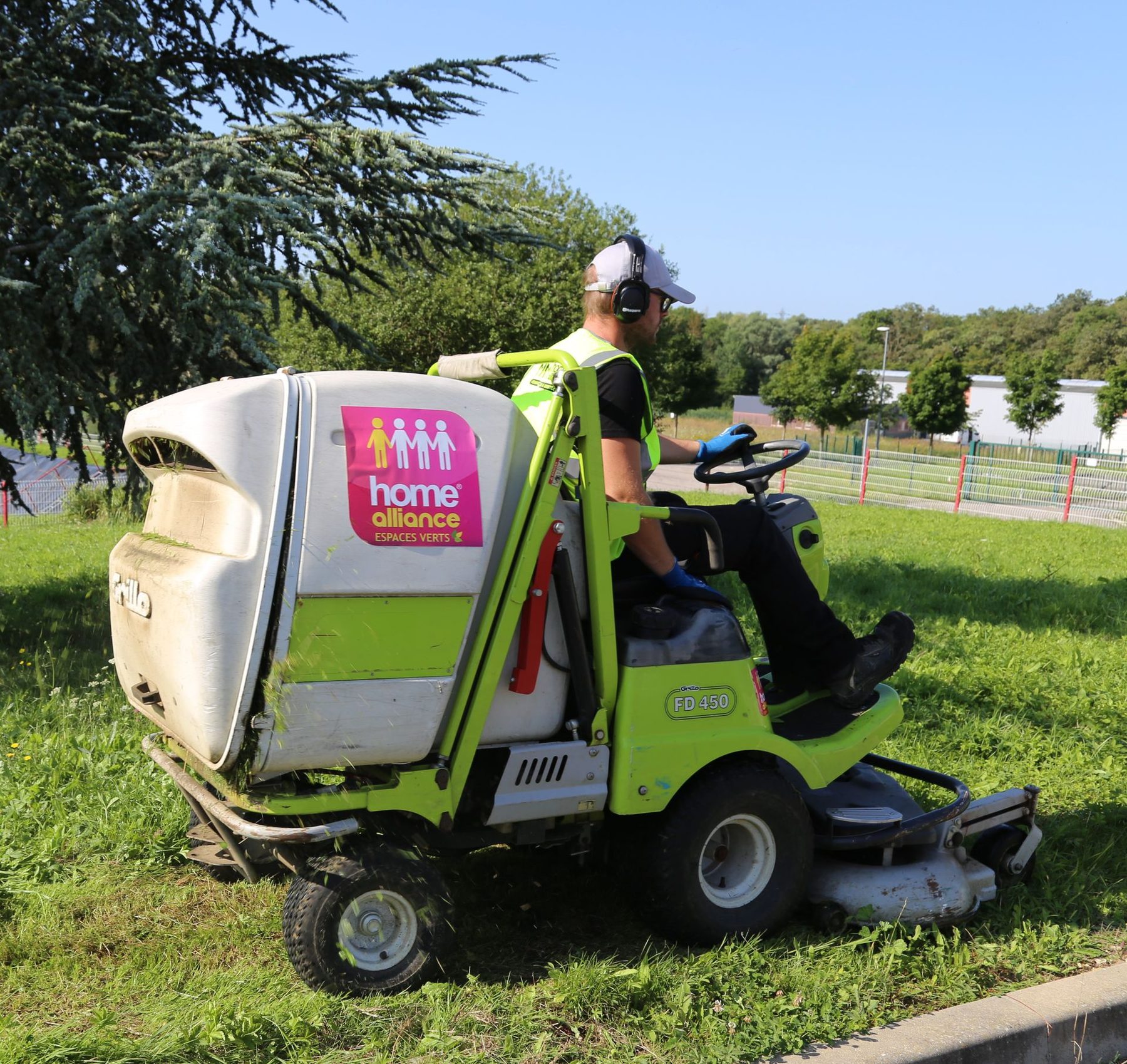 Un jardinier Home Alliance en tondeuse autoportée